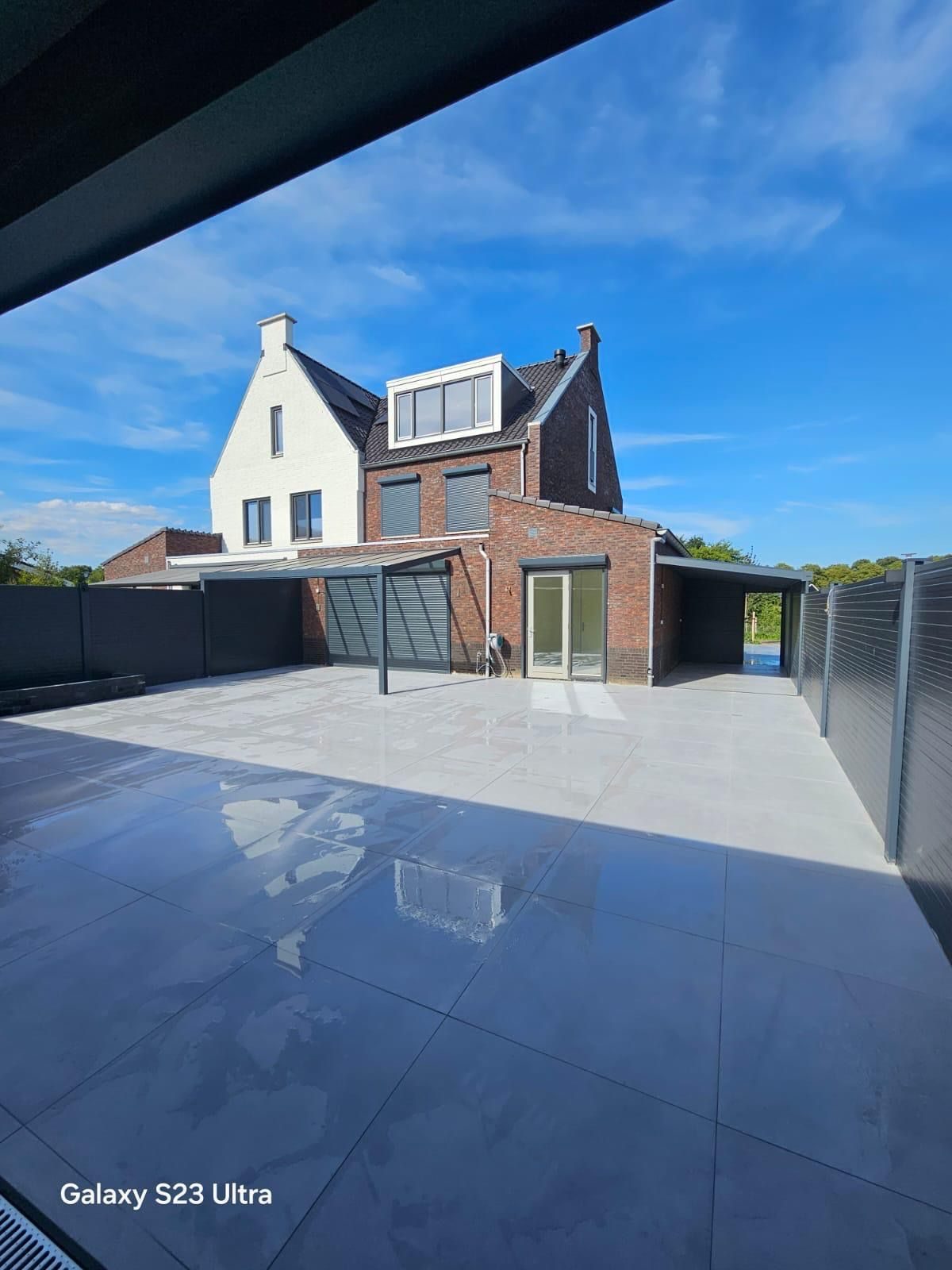 Glänzende anthrazitfarbene Terrassenplatten, unter einer Überdachung betrachtet