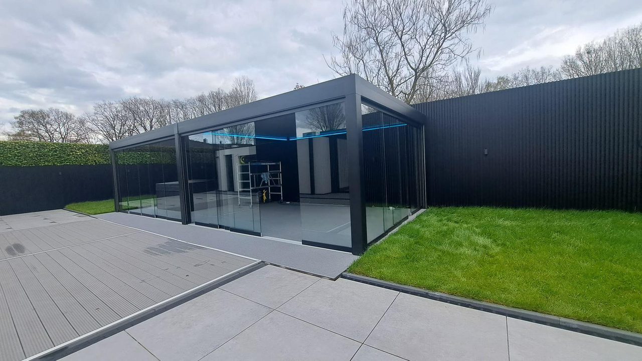 Freistehender Sommergarten mit Glasschiebewänden und stimmungsvoller Beleuchtung